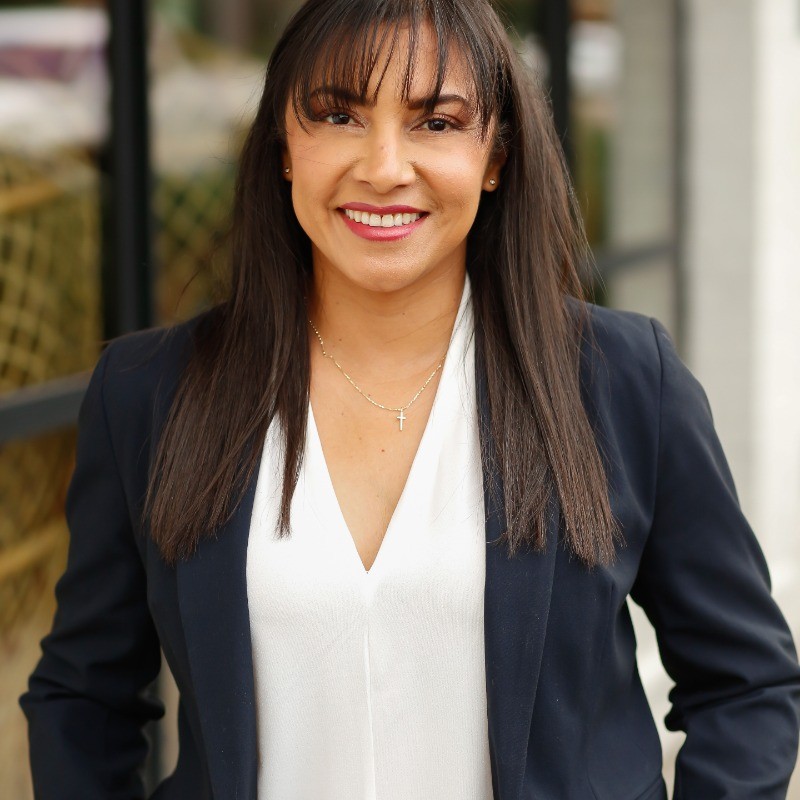 Portrait of Marcela Jimenez Ramirez smiling, wearing a navy blazer and white blouse